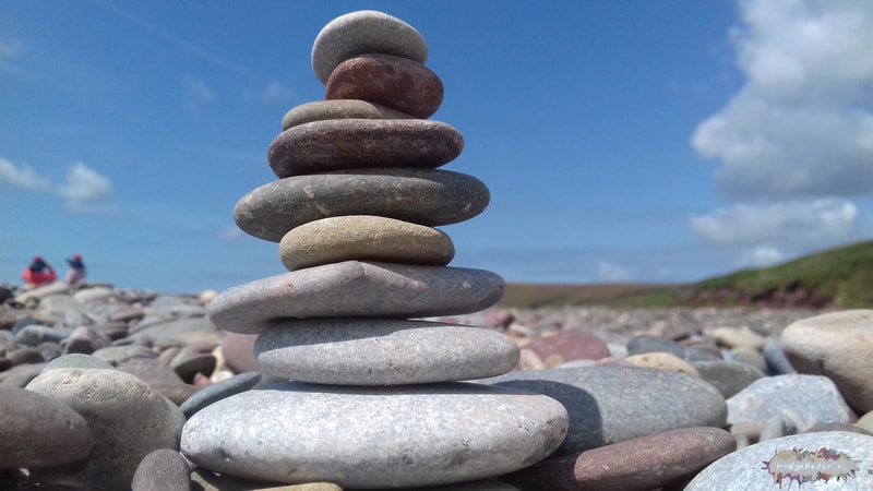Photograph of pebbles on a beach with blue sky