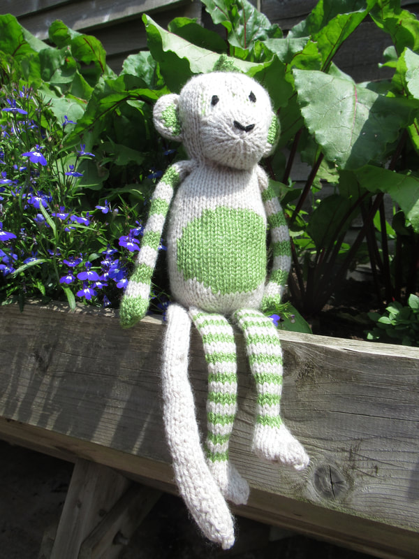 Photograph of handknitted cheeky monkey soft toy that is available to buy on Etsy