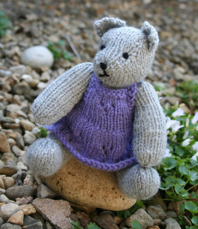 Small grey teddy bear hand knitted , with purple dress