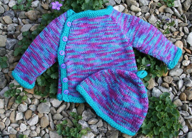A photograph of a 0-3 months jumper with buttons down the side. Matching hat. 