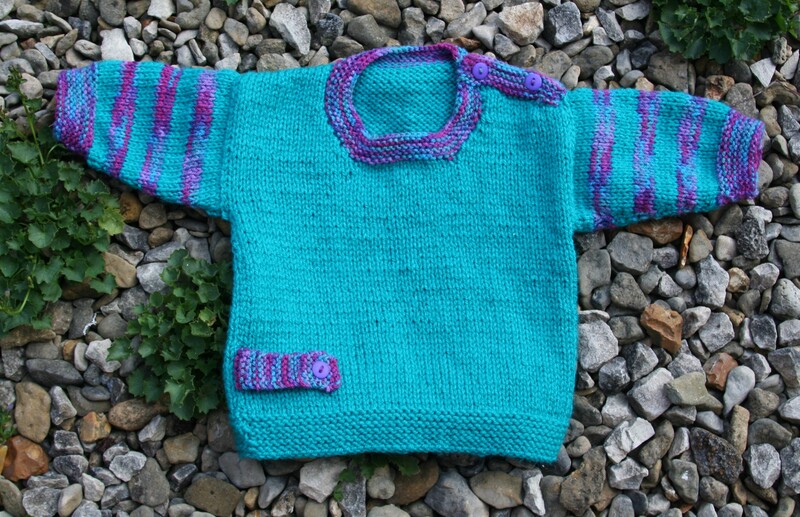 Photograph of green jumper with stripey arms and button details. Beautiful Multi colour, purple / pink / blue and green, yarn has been used for the accents