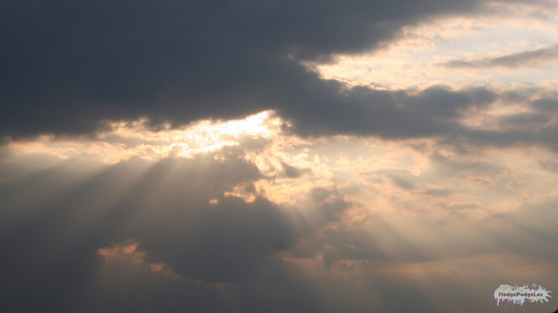 Photograph of the sun shining through a cloud